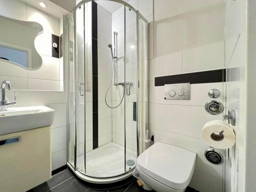 y baño con ducha, aseo y lavamanos. en Work&Stay Apartment - Kiel en Kiel