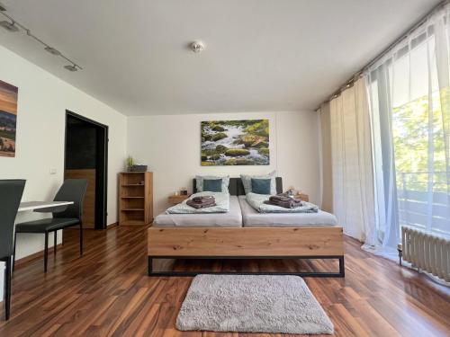 a bedroom with a bed and a desk in it at Helle FeWo am Waldrand - mit Balkon, Pool & Sauna in Freyung