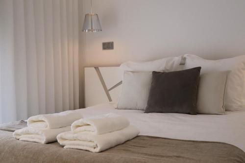 a bed with white towels sitting on top of it at Seaside XXI-10, By OP in Funchal