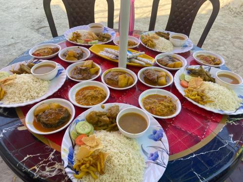 una mesa con platos de comida y arroz. en Tapama Resort en Bakkhali