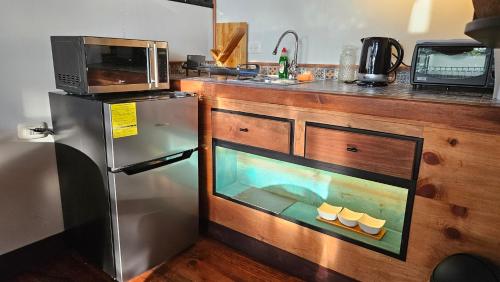 eine Küche mit einem Kühlschrank und einer Mikrowelle in der Unterkunft Lindo LOFT VIP a 5 minutos de Cayala in Guatemala
