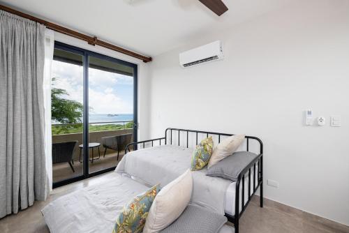 1 dormitorio con cama y vistas al océano en Casa Cito, en Playa Hermosa