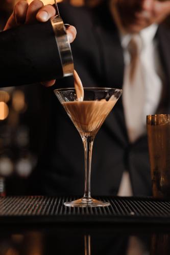 a bartender making a cocktail in a martini glass at GA Palace Hotel & Spa, a XIXth-Century Villa in Porto