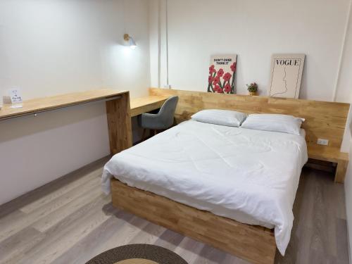 a bedroom with a large bed and a desk at Letter Better Home in Bangkok