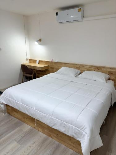 a large white bed in a room with a table at Letter Better Home in Bangkok