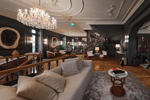 a living room with a couch and a chandelier at GA Palace Hotel & Spa, a XIXth-Century Villa in Porto