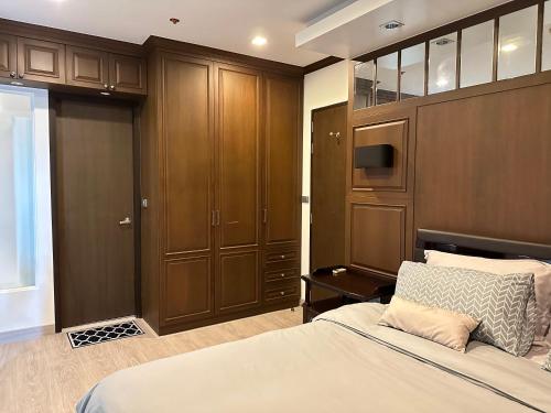 a bedroom with a bed and wooden cabinets at OV Residence in Bangkok