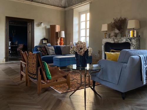 una sala de estar con sofás azules y una mesa. en The House, en Strevi