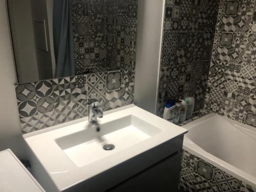 a bathroom with a white sink and a bath tub at Jolie chambre à Nanterre Préfecture proche La Défense Aréna Campus SNCF et Paris in Nanterre