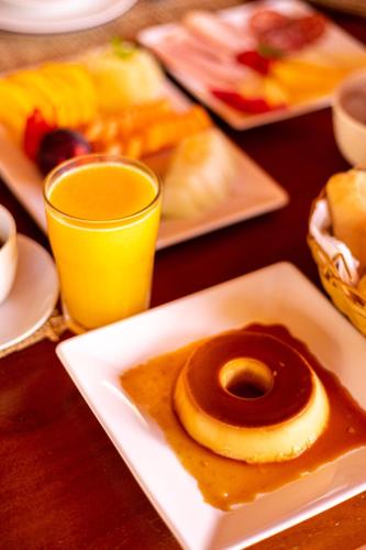 a plate with a chocolate doughnut and a glass of orange juice at Pousada Vila Sagui in Maragogi