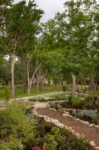 a garden with flowers and trees in a park at AustinTeton's Sunset Cliff Resort on Lake Travis - PRIVATE WEDDING, EVENT, HEATED POOL, BOAT DOCK in Austin