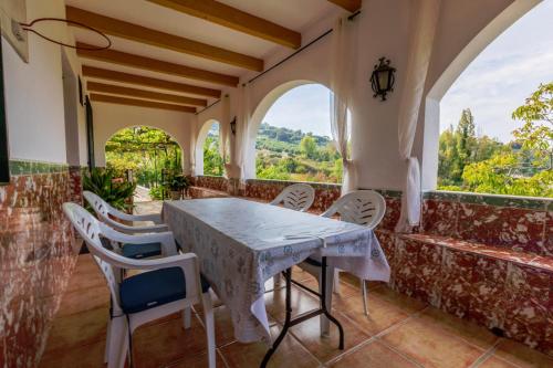 uma sala de jantar com mesa, cadeiras e janelas em Casa Jurinea Alzar em Torres