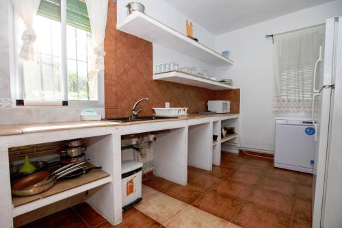 a kitchen with a counter and a sink and a refrigerator at Casa Jurinea Alzar in Torres