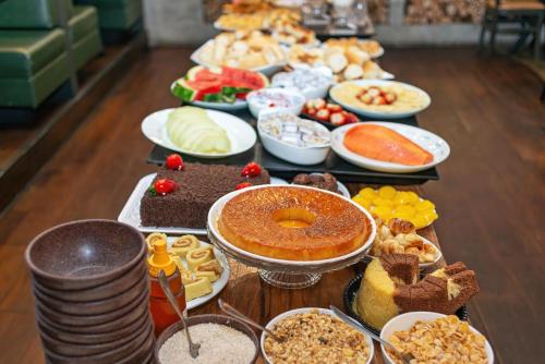 a table filled with different types of food and desserts at Capcana Hotel Jardins in Sao Paulo