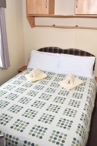 a bedroom with a bed with two hats on it at Albany Bronze - pet friendly LC10 in Minehead