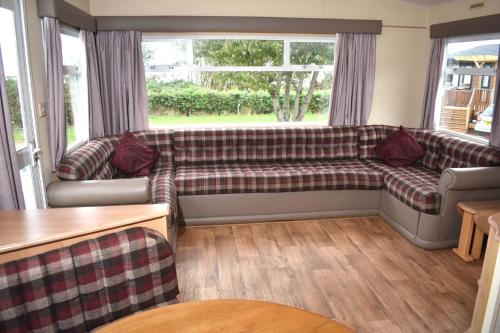 ein Wohnzimmer mit einem Sofa und einem Fenster in der Unterkunft Albany Bronze - pet friendly LC10 in Minehead