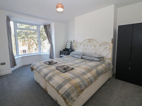 um quarto com uma cama grande e uma janela em Flat 2 Englehurst Mews em Buxton