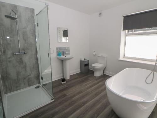 uma casa de banho com um chuveiro, uma banheira e um WC. em Flat 2 Englehurst Mews em Buxton