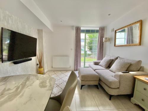 sala de estar con sofá y TV en Cosy 1 bed “pied-a-terre”, en Northampton