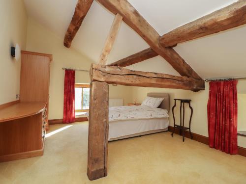 - une chambre avec un lit et des poutres apparentes dans l'établissement Grains Barn Farm, à Burnley