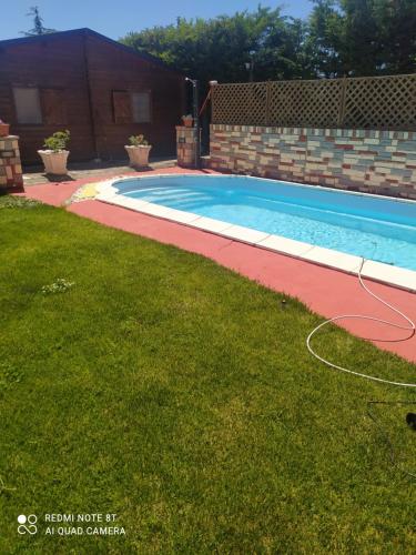 a swimming pool in a yard next to a grass field at casa marina in Tito