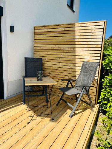 a wooden deck with a table and a chair at Ferienwohnung EnsheimLiebe in Saarbrücken