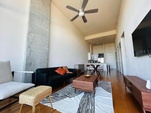 a living room with a couch and a ceiling fan at 1 BR King Bed Downtown Oasis Heart Of Austin in Austin