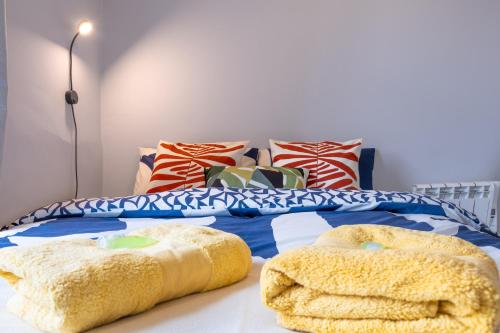 a bed with colorful pillows and towels on the floor at Beautiful Ground Floor Apartment in Perth