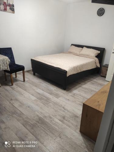 una camera da letto con un letto e una sedia di Garsoniera Turda Maria a Turda