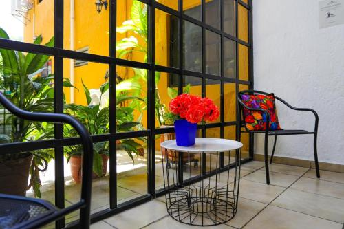 Un balcón con una mesa y un jarrón con flores. en Hotel Hacienda Cancun en Cancún
