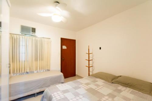 a bedroom with a bed and a window and a couch at HOSTEL DIKASA in Cuiabá