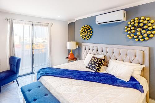 um quarto com uma cama grande e uma parede azul em Alina 203a @ Morgan Residences em Cabo San Lucas