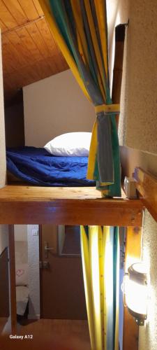 um beliche com uma cortina azul e amarela em studio-cabine 4 pers, wifi et garage. em Ax-les-Thermes