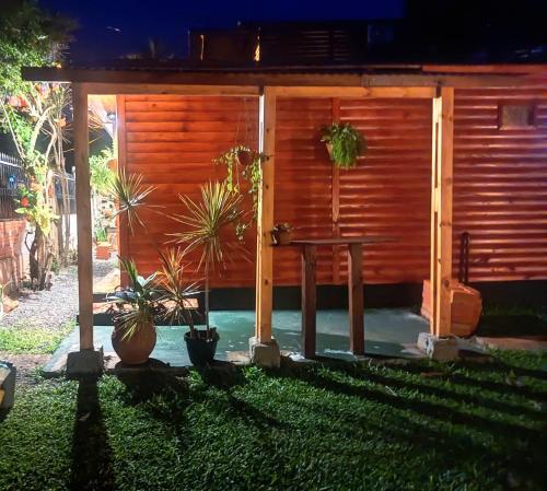 a patio with a table and potted plants in a yard at Cabaña Joshua in Puerto Iguazú