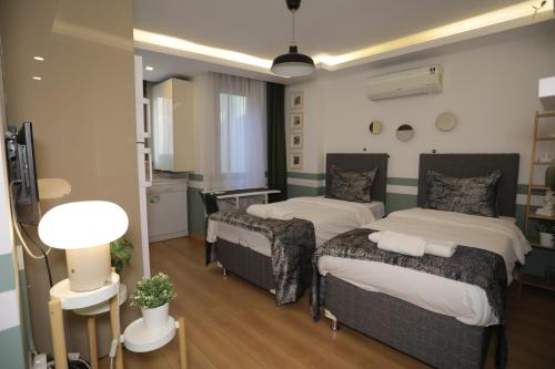 una camera con due letti e un tavolo con una lampada di İstanbul Relax Suite a Istanbul