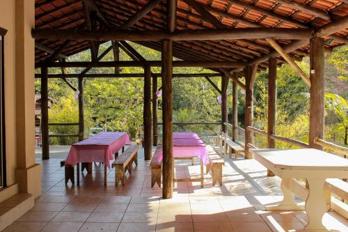 een groep tafels en banken in een paviljoen bij Sítio Monte Sião in Major