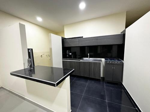 a kitchen with a sink and a stove in it at Apartamentos Sin fronteras in Leticia