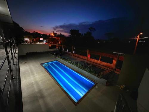 a swimming pool with blue lighting on a balcony at night at Apartamentos Sin fronteras in Leticia