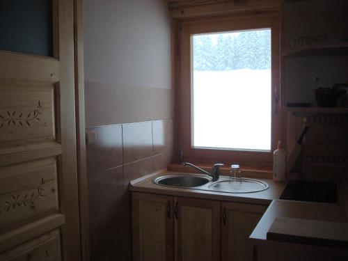 una cocina con fregadero y ventana en Chata Istebna, en Istebna