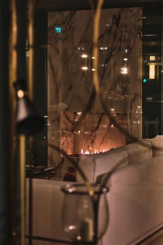 a fireplace in a room with a table and a lamp at GA Palace Hotel & Spa, a XIXth-Century Villa in Porto