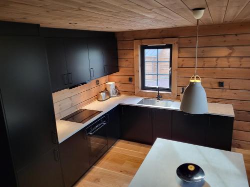 a kitchen with black cabinets and a sink and a window at Idre Mountain Lodge in Idre