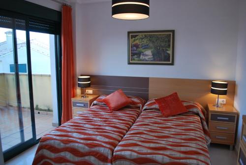 Un dormitorio con una cama con almohadas rojas. en Apartamentos Lomas De Campoamor, en Campoamor