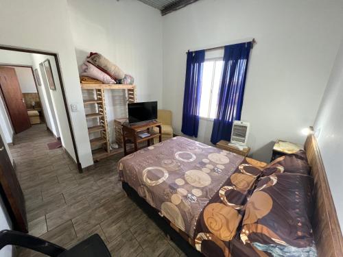 a bedroom with a bed and a desk and a window at Puesta del Sol in Campo Quijano