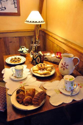 a table with plates of pastries and cups of tea at L'Ancien Paquier Chambre D'Hotes in Valtournenche