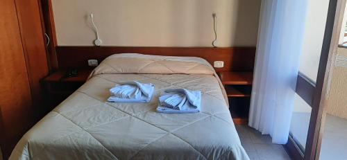 een bed met twee blauwe handdoeken erop bij POUSADA DO SERRANO 318 in Gramado