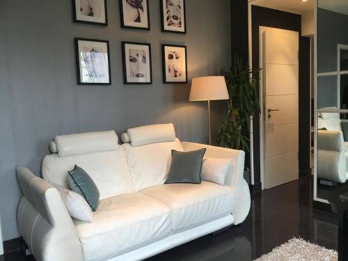 a white couch in a living room with pictures on the wall at Suite Couture in Ernestviller
