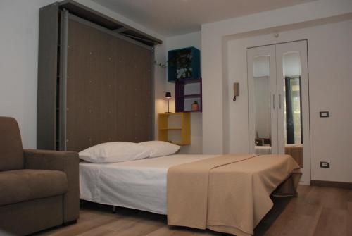 ein Schlafzimmer mit einem Bett und einem Sofa in der Unterkunft Giardino del Mare in Bordighera