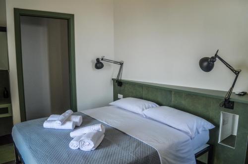 a bed with two towels and two lamps on it at Scavi 32 in Ercolano