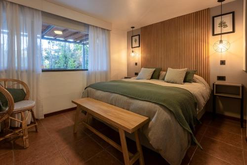a bedroom with a bed and a table and a window at Cabañas Rio Soñado in Valle Grande