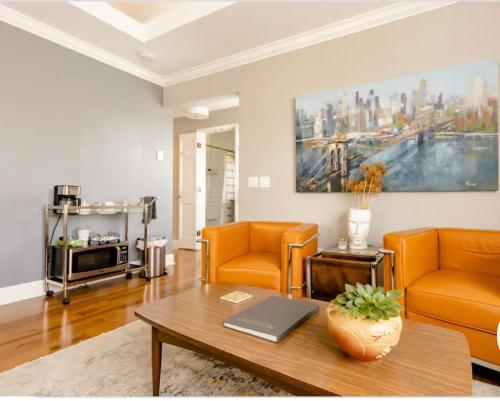 a living room with orange chairs and a table at Pittsford Garden Retreat in Pittsford